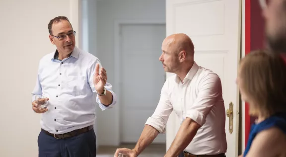 two men standing in a meeting room